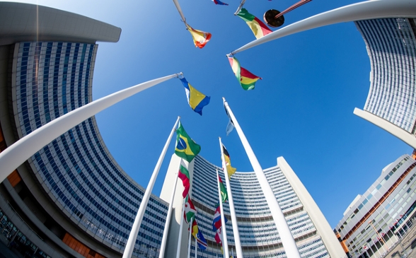 A multi-storey modern building with flags of different nations .