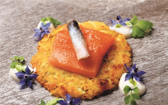 Röstis suisses accompagnant un filet de saumon et des rouleaux de poisson. 