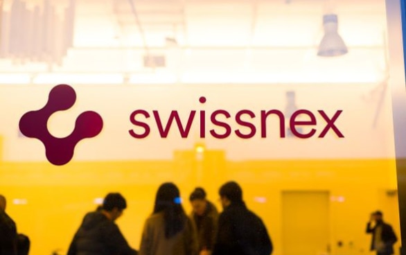 Puerta vidriera de Swissnex, en el fondo se ve un grupo de personas reuniéndose. 