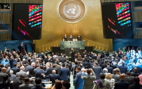 In the general assembly hall of the UN in New York, the high-level government representatives of the UN member states applaud the adoption of the 2030 Agenda.
