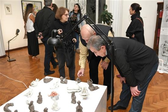 Attendants discuss sculptures at the "Strangers in the Room" exhibition by Gohar Sargsyan 