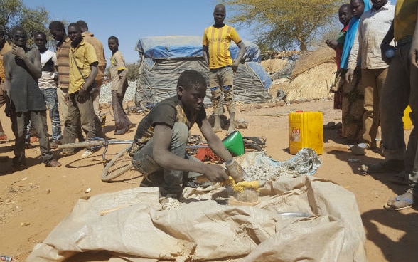 Photo d'un adolescent qui concasse manuellement la roche aurifère dans un site artisanal à Zanna-Burkina Faso