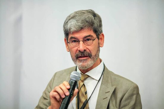 Werner Thut sitting in the panel addresses the conference participants