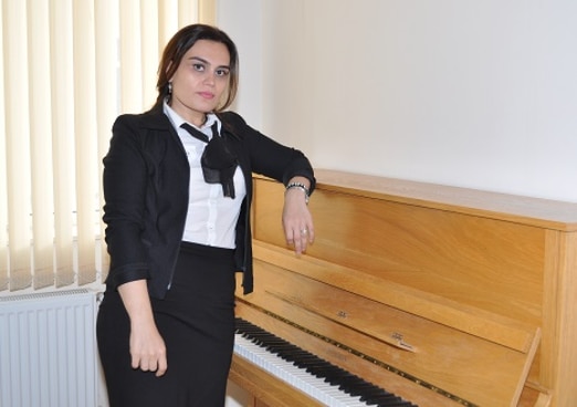 A young azeri woman posing next to her piano