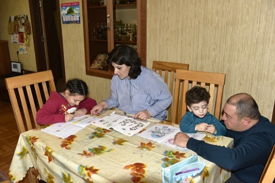 Kakha and his wife help kids with homework 