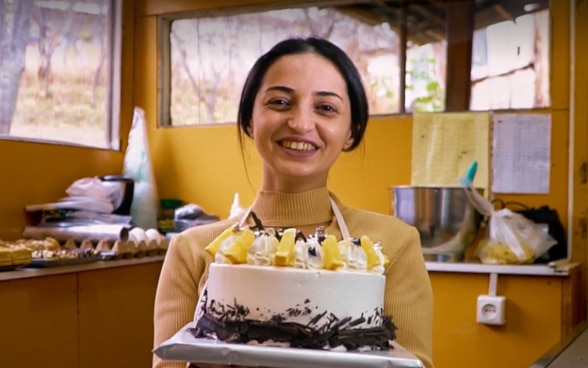 Veronika holds in her hands the cake she baked