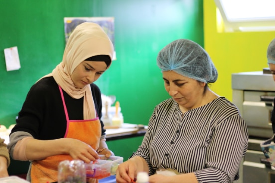 two women cook together in the kitchen