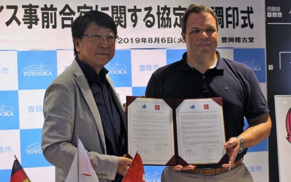 スイスボート連盟・豊岡市/事前合宿に関する協定書調印式にて。左:中貝宗治市長 右:スイスボート連盟ディレクターのクリスチャン・ストファー氏(2019年8月6日)©豊岡市