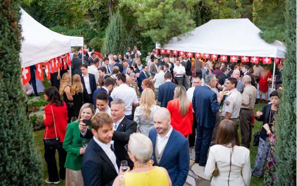 Guests of the Swiss National Day 2024 reception in the Swiss Residence garden