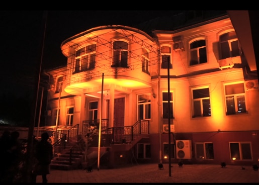 The SCO Tajikistan office building illuminated with orange light