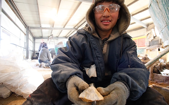 Jeune mineur montrant un extrait de minerai d’or.