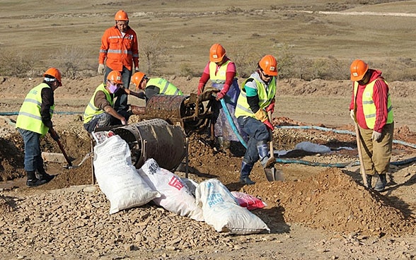 Minenarbeiterinnen und Minenarbeiter heben auf der Suche nach Gold von Hand Löcher in den Boden. Durch die Formalisierung des Kleinbergbaus in der Mongolei sind die Minenarbeiterinnen und Minenarbeiter nicht nur besser geschützt, sondern auch verpflichtet, ökologische und soziale Mindeststandards einzuhalten.