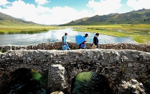 Mädchen laufen in Peru über eine Brücke.