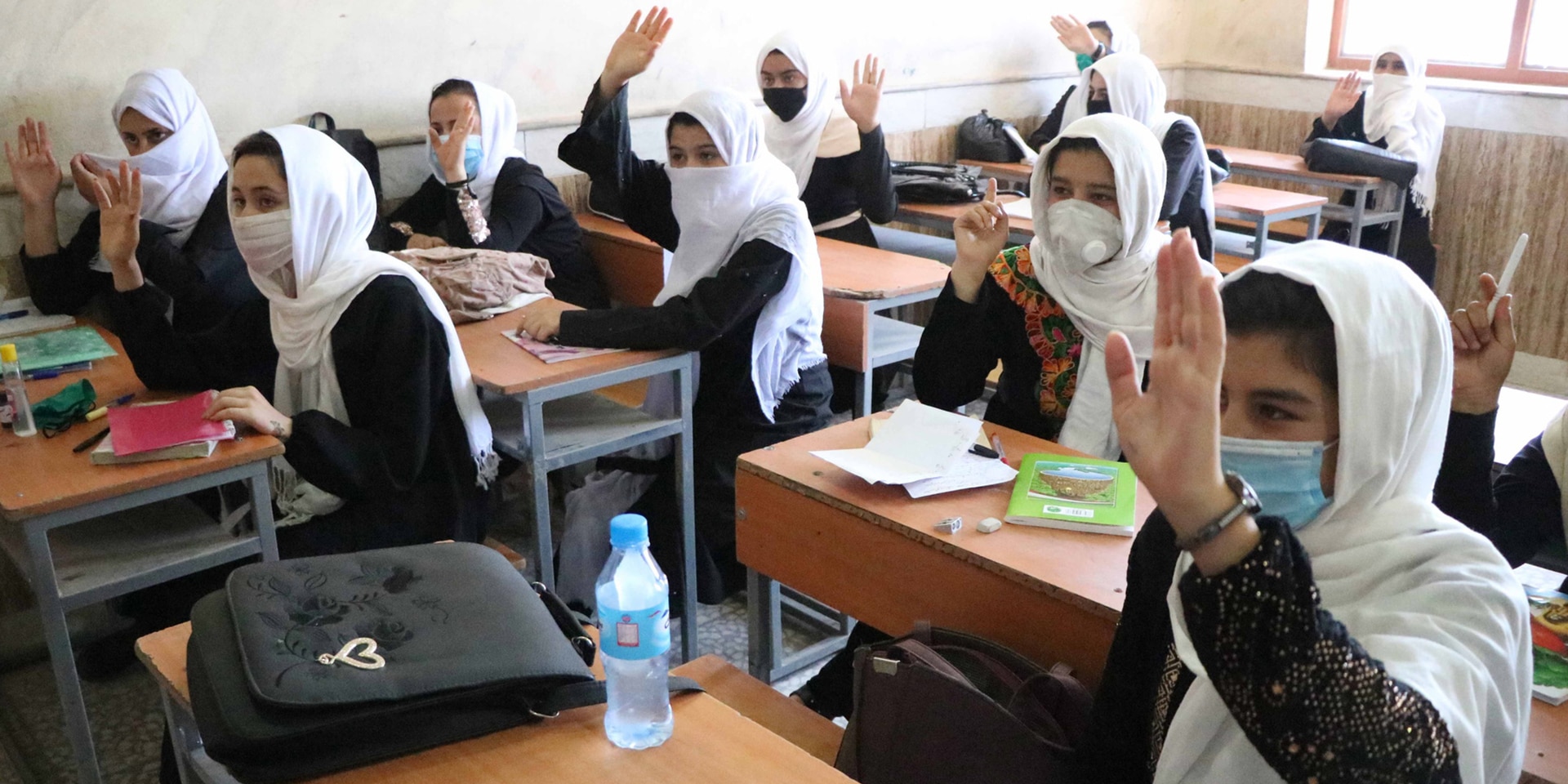  A classroom in Afghanistan where girls put their hands up to answer a question.