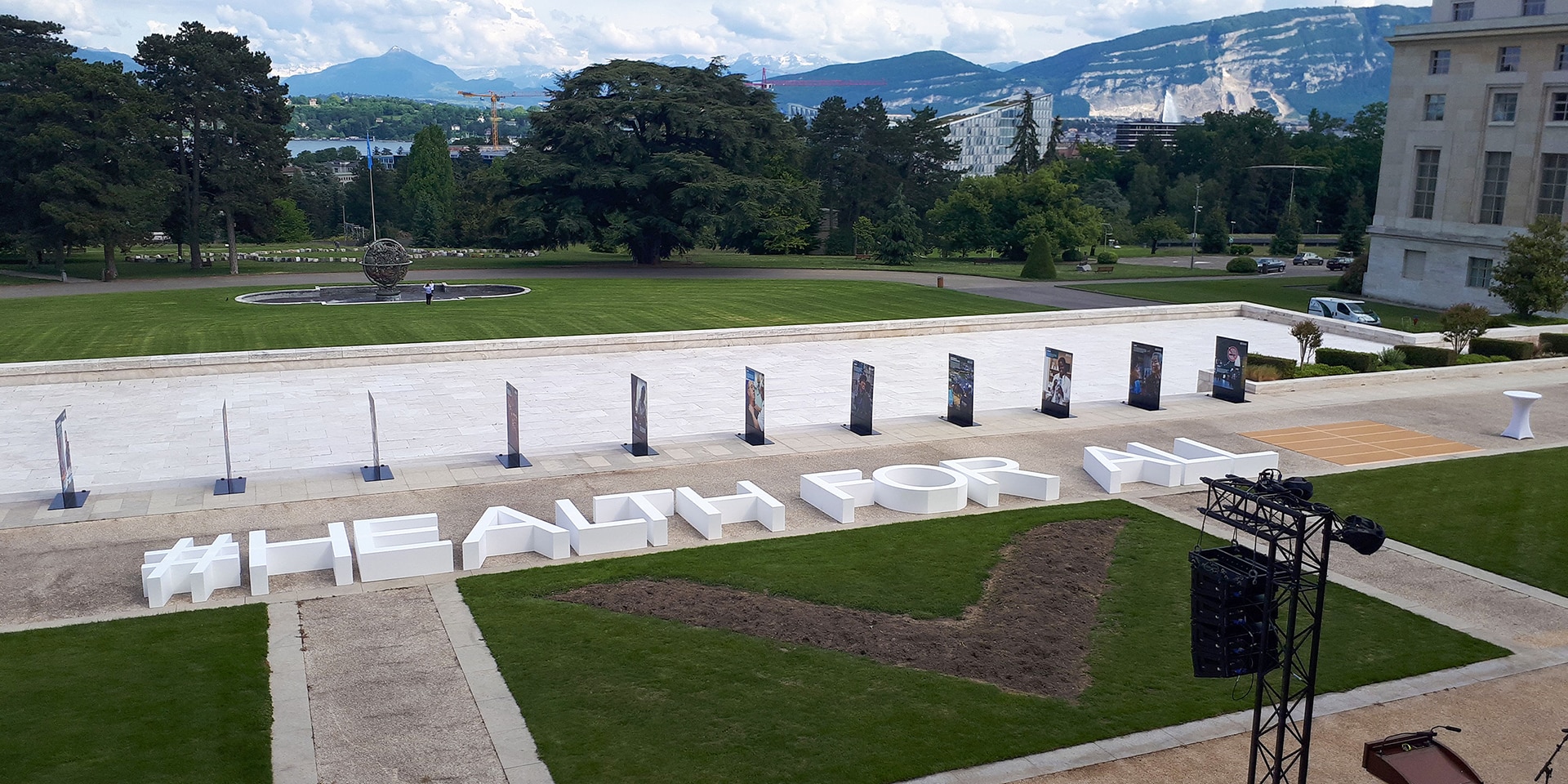 On the lawn in front of the United Nations' main building in Geneva, the words #HEALTH FOR ALL are written in large letters.