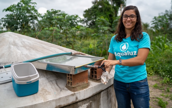 Anna Luisa Beserra, Jungunternehmerin aus Brasilien, neben einem Wassertank.