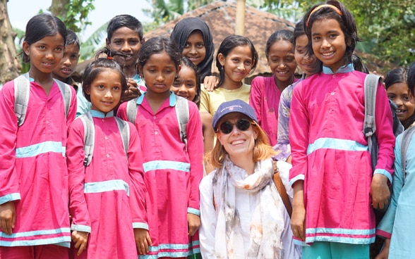 Swiss ambassador Nathalie Chuard with a group of schoolgirls in uniform.