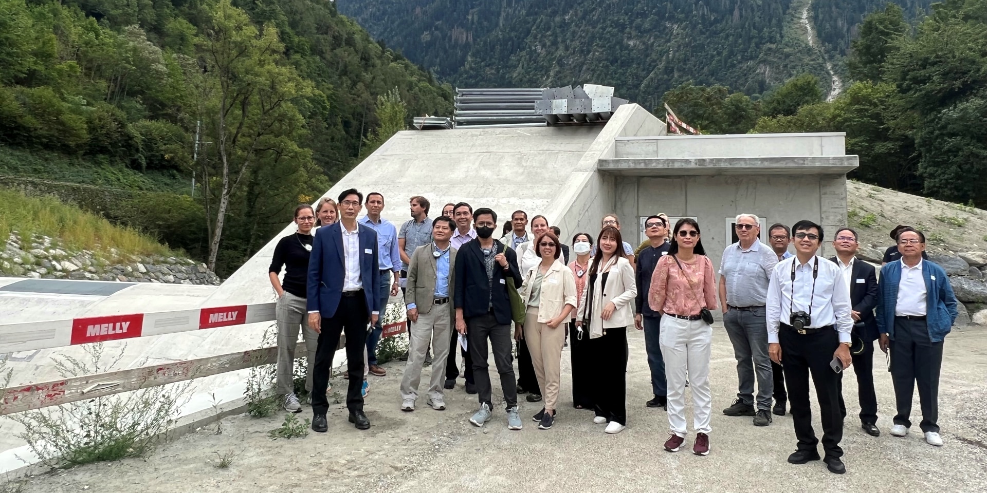 Les deux délégations asiatiques posent devant un barrage à Martigny.