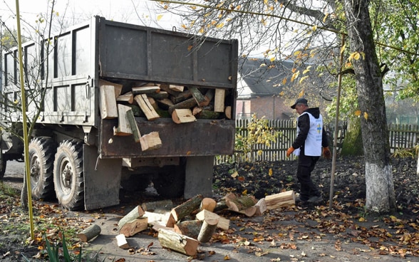 A man stands in front of a truck.