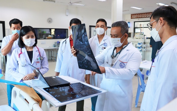 Visita mattutina in un ospedale pediatrico Kantha Bopha. Un medico osserva la radiografia di un paziente.