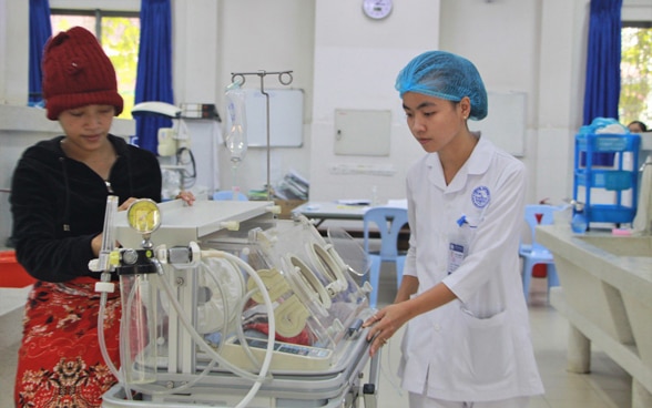 Clinica ostetrica di Siem Reap: un’infermiera e una madre davanti a un neonato.