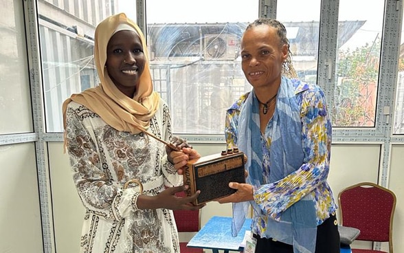 Patricia Danzi standing next to a young Chadian journalist, Hawa Mahamat Adouma, from Radio Ndarason, holding a transistor.