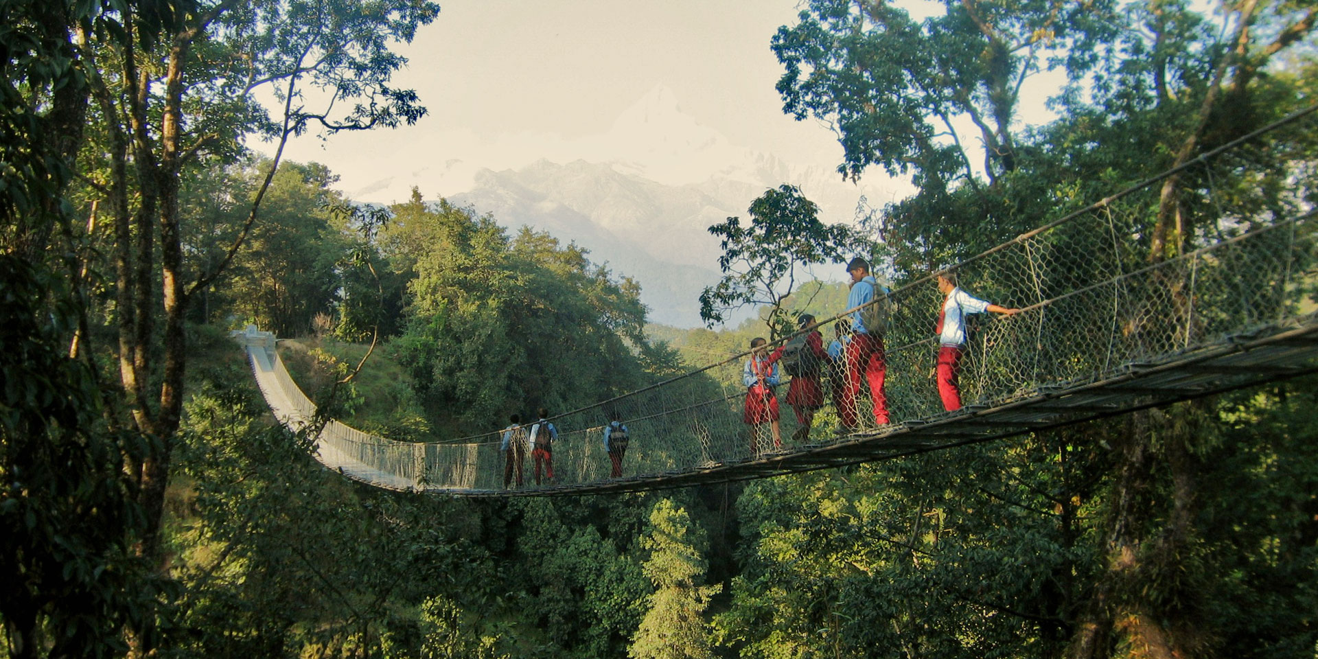 Des écoliers sur un pont suspendu.