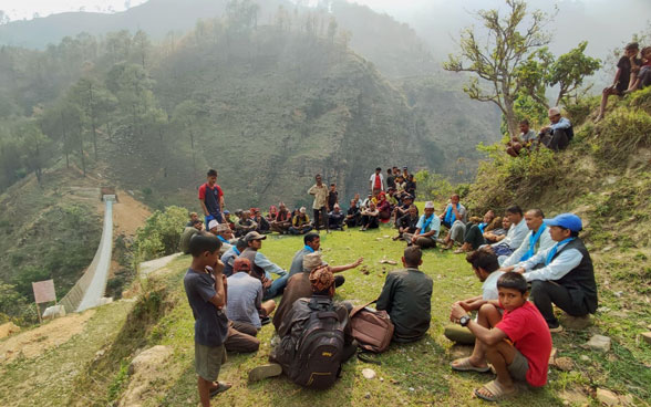 People sitting in a circle on a hill.