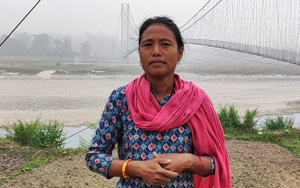 Une femme regarde la caméra, avec le pont suspendu en arrière-plan.