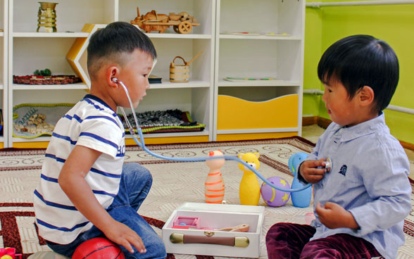 Bambini giocano in un asilo dotato di riscaldamento.