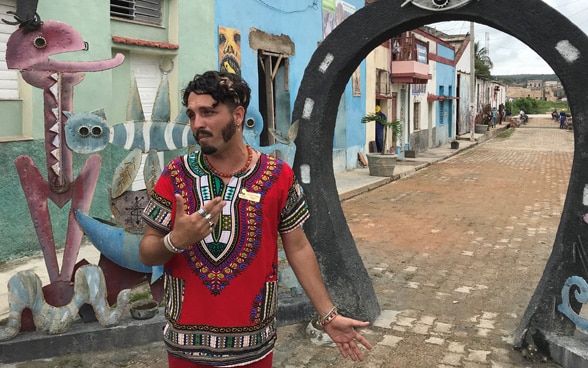A Cuban LGBT activist stands on the street.