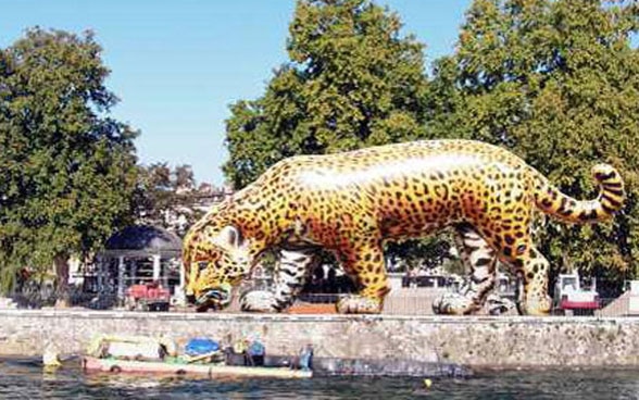 Un gran jaguar de plástico aparece erguido a la orilla de la Isla Rousseau en Ginebra.