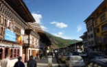 Un Suisse et deux Bhoutanais marchent ensemble dans une rue de la capitale Timphu.