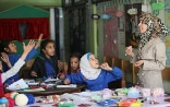 Des filles sont dans une classe à Khan Dunnoun en Syrie et elles écoutent attentivement leur enseignante.