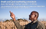 Ein Mann wirft mit einer Hand Samen in die Luft. Er steht vor hohen, braunen Halmen und im Hintergrund sieht man die Skyline einer Stadt.