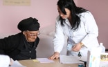 Une femme âgée reçoit une ordonnance dans un établissement de soins de santé en Albanie.