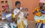 En la foto, tres mujeres con sus bebés; dos de ellas, dándoles de comer. 