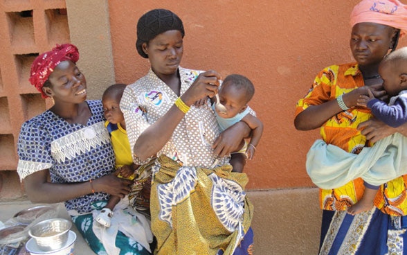 Trois femmes portant chacune un bébé dans les bras. Deux d’entre elles donnent à manger à leur enfant. 