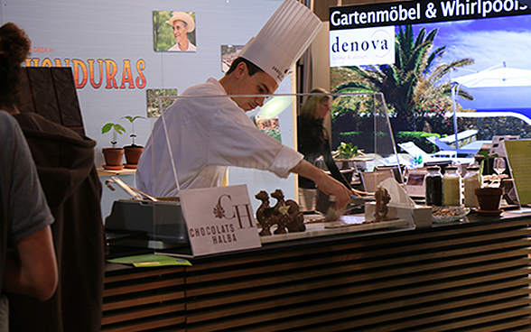 Mostra speciale della DSC all'OLMA 2015: un uomo fonde la cioccolata allo stand sull'Honduras. 