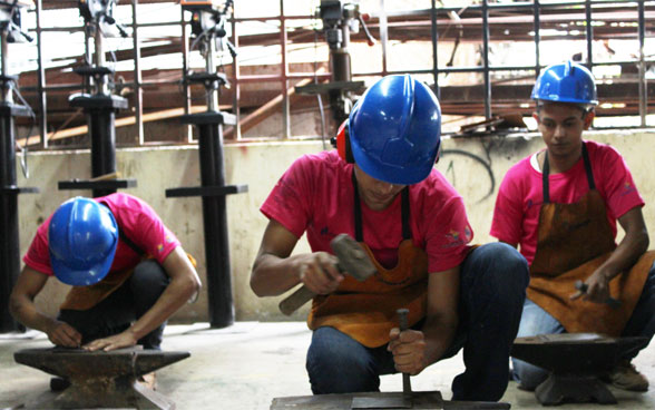 Deux jeunes hommes travaillent sur un chantier.