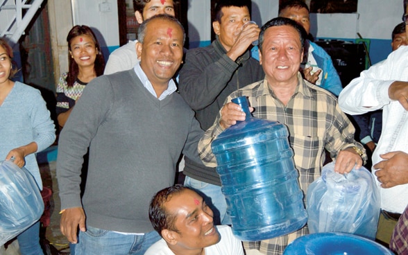 Groupe de personnes célébrant leur accès à l'eau potable grâce à une technologie avancée.