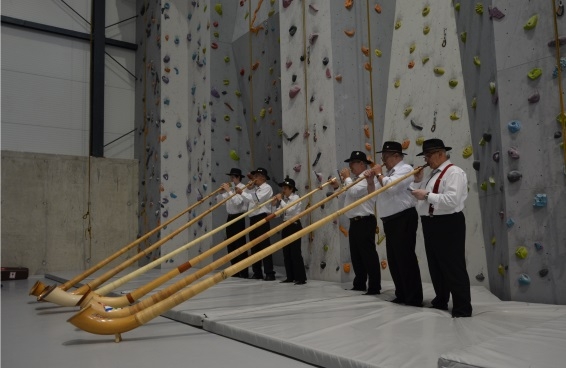 Sechs Schweizer Musiker in Tracht geben ein Alphornkonzert im neuen Kletterzentrum der Stadt Sátoraljaújhely.