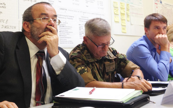 Swiss Army representatives listen attentively.