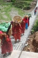 Frauen mit Tragkörben begehen eine Fussgängerbrücke.