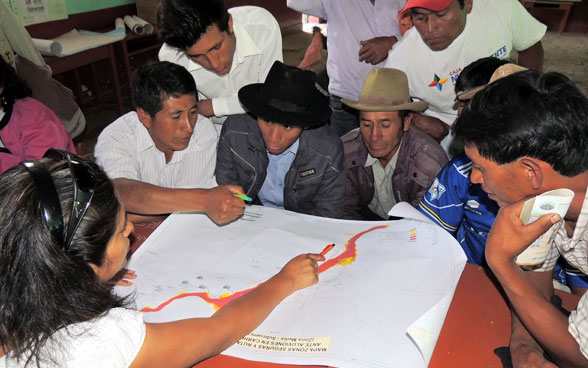 Peruanische Bürgerinnen und Bürger folgen den Erläuterungen einer Fachfrau. 