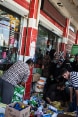 Bedürftige Menschen im Iraq stehen an einer Verteilstation von Lebensmitteln und anderen Gütern vor einem Supermarkt.