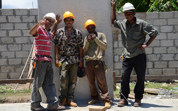 Quatre ouvriers haïtiens posent le temps d’une photo sur le chantier.  © DDC