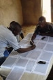 A group of men marking things on a map.