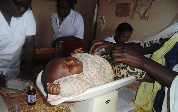 Un bambino viene pesato in un ambulatorio.