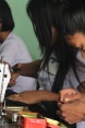 Junge Frauen in Myanmar arbeiten an Nähmaschinen.